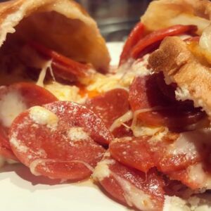 Customizable cheese calzone with various toppings and premium add-ons.