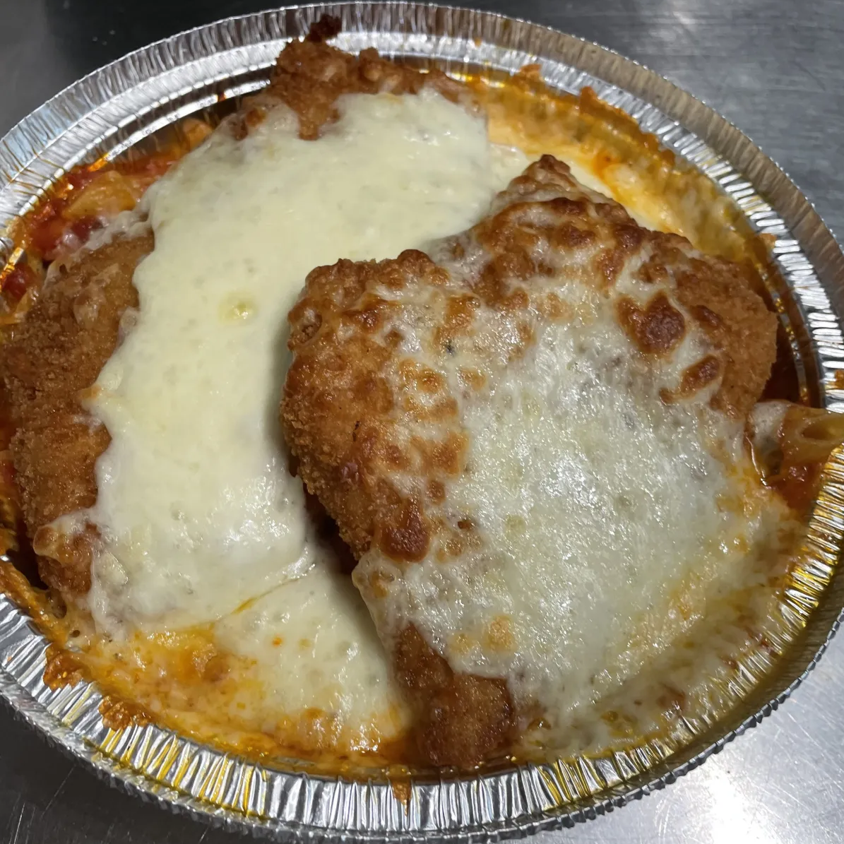 Chicken alla Parmigiana Dinner with marinara sauce and melted mozzarella cheese, served with a choice of spaghetti, ziti, or gluten-free ziti.