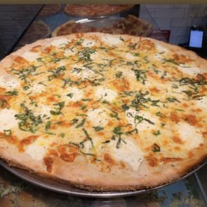 A Formaggio Bianco white pizza topped with fresh ricotta cheese, aged mozzarella, Parmigiano Reggiano, basil, and a drizzle of olive oil.