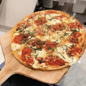 Gluten-free Regina pizza topped with homemade marinara sauce, fresh basil leaves, fresh mozzarella, Parmigiano Reggiano, and drizzled with imported cold-pressed virgin olive oil on a crispy gluten-free crust.