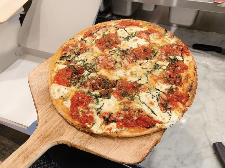 Gluten-free Regina pizza topped with homemade marinara sauce, fresh basil leaves, fresh mozzarella, Parmigiano Reggiano, and drizzled with imported cold-pressed virgin olive oil on a crispy gluten-free crust.