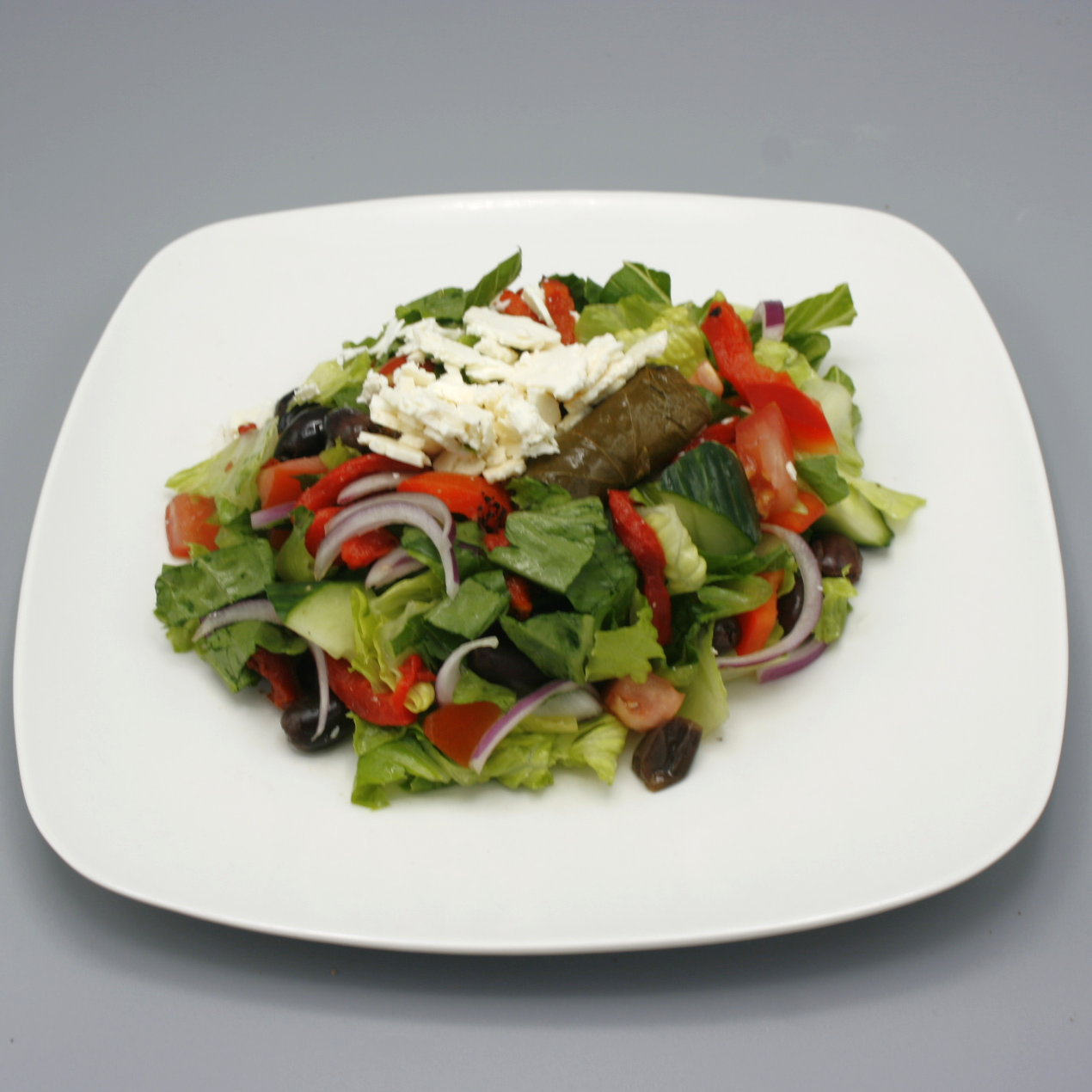 Greek salad with romaine lettuce, green and red peppers, cherry tomatoes, cucumbers, feta cheese, and Kalamata olives.