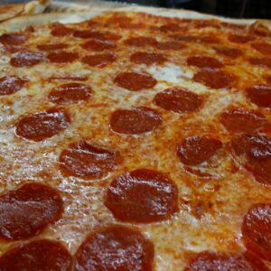 A pepperoni pizza with a crispy crust, covered in melted cheese and evenly distributed pepperoni slices.