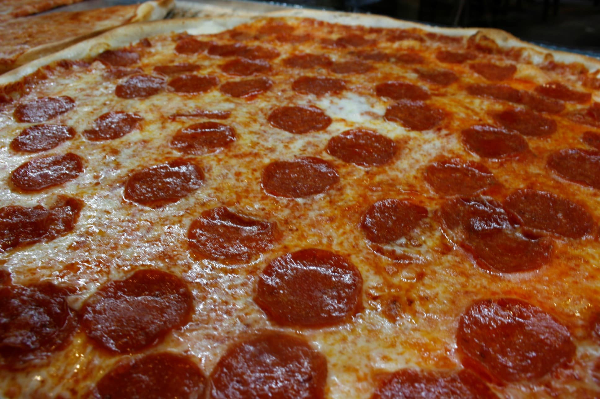 A pepperoni pizza with a crispy crust, covered in melted cheese and evenly distributed pepperoni slices.