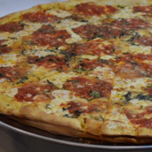 A delicious Regina Napoletana pizza with a crispy crust, topped with marinara sauce, fresh basil leaves, mozzarella, and Parmigiano Reggiano, drizzled with olive oil.